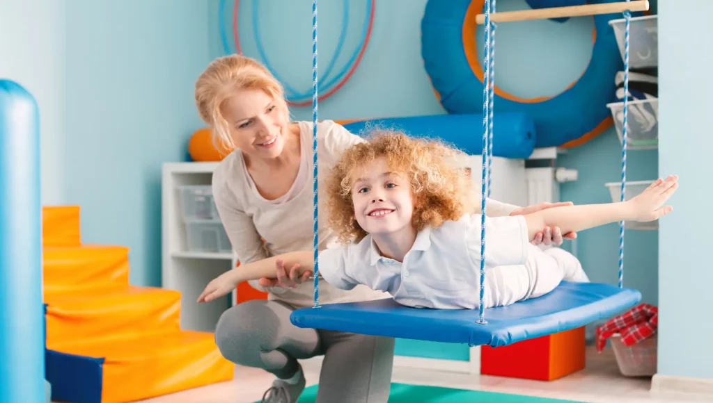 blonde Frau verrichtet therapeutische Übungen mit Kind