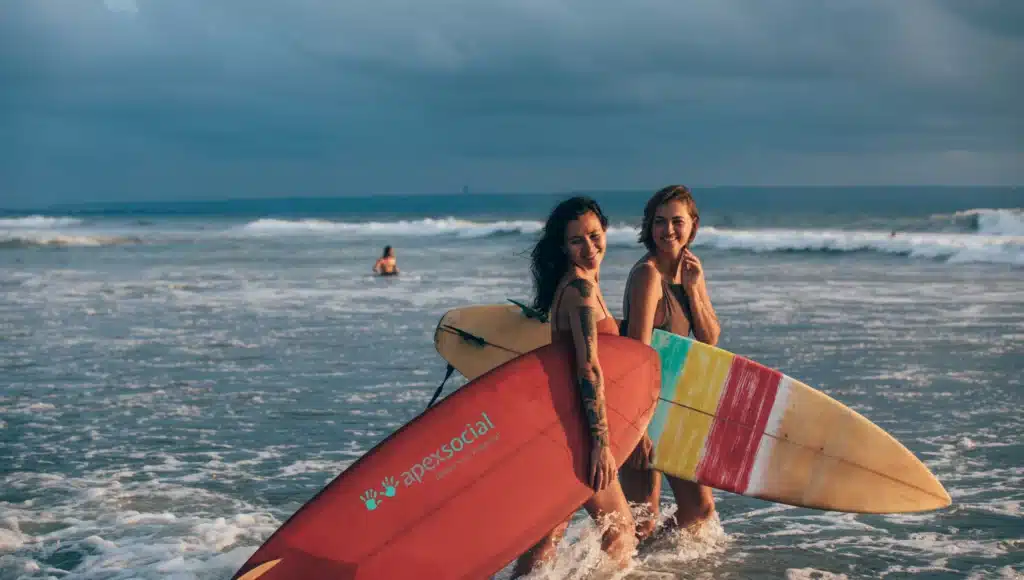 2 Frauen mit Surfboards im Meer