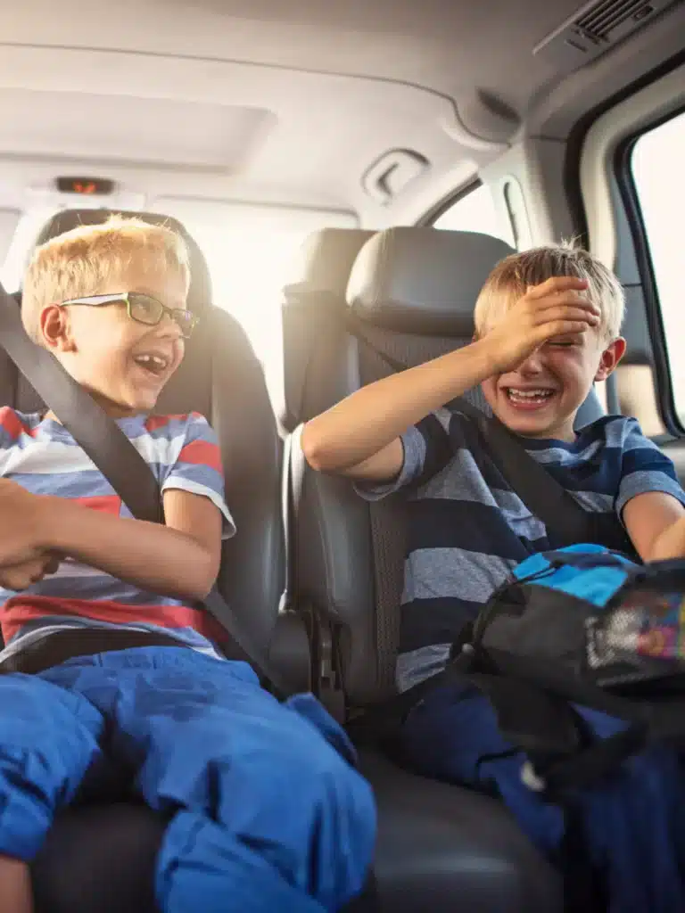 2 Kinder lachen in einem Auto