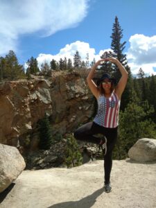 Eine Frau macht Yoga an der Klippe eines Felsens
