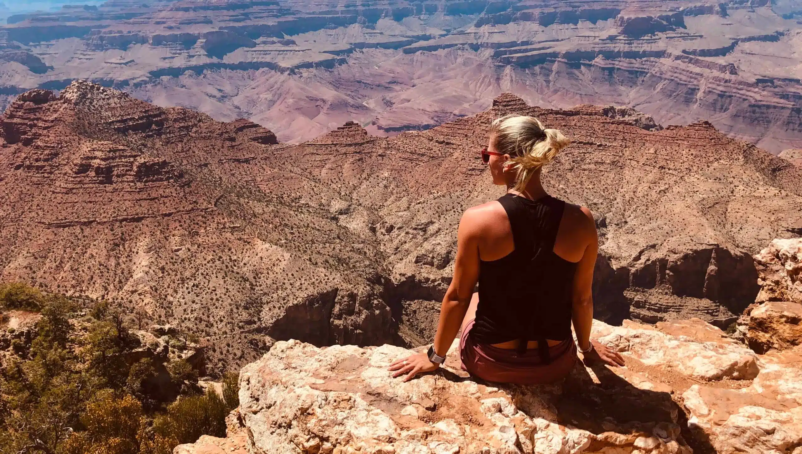 Eine Frau sitzt an einer Klippe eines Canyons