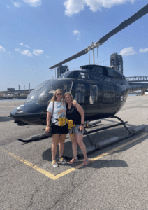 Two women standing near a helicopter